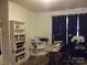 Bright home office with hardwood floors, built-in shelving, and a large window with dark curtains at 1502 Mulberry Ridge Dr # 1, Newton, NC 28658