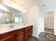 Bathroom vanity featuring double sinks, wood cabinets, a mirror and a view of the walk-in closet at 1523 Loropetalum Rd, Charlotte, NC 28215