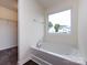 Bathroom featuring soaking tub with view, window, and walk-in closet at 1523 Loropetalum Rd, Charlotte, NC 28215