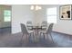 Bright dining area with contemporary chandelier, four stylish gray chairs, and glass-topped table at 1523 Loropetalum Rd, Charlotte, NC 28215