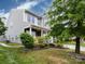 Side view of a two-story house showing green siding, white windows, and lush landscaping at 1523 Loropetalum Rd, Charlotte, NC 28215
