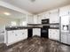 Modern kitchen with stainless steel refrigerator, black appliances, and white cabinets at 1523 Loropetalum Rd, Charlotte, NC 28215