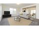 Comfortable living room with modern furnishings, a plush sofa, and a glass coffee table at 1523 Loropetalum Rd, Charlotte, NC 28215