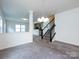 Open-concept living area with view of the staircase and partial wall dividing the kitchen at 1523 Loropetalum Rd, Charlotte, NC 28215