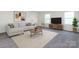 Well-lit living room with modern furniture and decor, including a large sofa and entertainment center at 1523 Loropetalum Rd, Charlotte, NC 28215