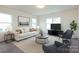 Bright living room featuring neutral walls, carpet, contemporary furniture, and natural light from multiple windows at 1523 Loropetalum Rd, Charlotte, NC 28215