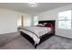 Bedroom featuring grey carpet, neutral walls, natural light, and a bed with decorative pillows at 1523 Loropetalum Rd, Charlotte, NC 28215