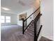 Carpeted staircase with white railings and black trim leads to the upper level at 1523 Loropetalum Rd, Charlotte, NC 28215