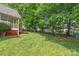 Expansive backyard featuring lush greenery, storage sheds, and a charming covered porch at 1542 Crowders Woods Dr, Gastonia, NC 28052