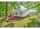 A large grassy backyard showing the home's exterior, trees, and a manicured yard with a cozy screened porch at 1542 Crowders Woods Dr, Gastonia, NC 28052