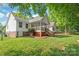 Backyard view of the home featuring a spacious yard, a screened-in porch, and mature trees at 1542 Crowders Woods Dr, Gastonia, NC 28052