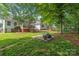 Large backyard with a fire pit and patio area, surrounded by mature trees at 1542 Crowders Woods Dr, Gastonia, NC 28052