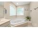 Relaxing bathroom with soaking tub, privacy windows, and tile surround at 1542 Crowders Woods Dr, Gastonia, NC 28052