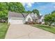 Traditional home featuring a two-car garage and well-manicured landscaping at 1542 Crowders Woods Dr, Gastonia, NC 28052