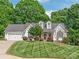 Charming two-story home with a well-manicured lawn, attached garage, and vibrant landscaping, creating a welcoming curb appeal at 1542 Crowders Woods Dr, Gastonia, NC 28052