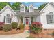 Inviting front porch with rocking chairs, a red door, and lush landscaping, creating a warm and welcoming entrance at 1542 Crowders Woods Dr, Gastonia, NC 28052