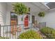 Welcoming front porch with rocking chairs and ferns, offering a cozy space to relax and enjoy the neighborhood view at 1542 Crowders Woods Dr, Gastonia, NC 28052