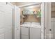 Convenient laundry room with washer, dryer, and shelving for storage, behind double doors at 1542 Crowders Woods Dr, Gastonia, NC 28052