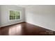 Bright bedroom features hardwood floors and a large window with view of green trees at 15923 Prescott Hill Ave, Charlotte, NC 28277