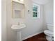 View of half bathroom with pedestal sink, mirror, and dark hardwood floors at 15923 Prescott Hill Ave, Charlotte, NC 28277