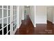 View of hallway with hardwood floors, wainscoting, and glass paneled french doors at 15923 Prescott Hill Ave, Charlotte, NC 28277