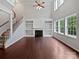 Spacious living room with hardwood floors, fireplace, built-in shelving, and large windows at 15923 Prescott Hill Ave, Charlotte, NC 28277