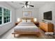 Modern bedroom with a wooden bed frame and neutral color palette at 15923 Prescott Hill Ave, Charlotte, NC 28277