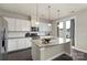 Modern kitchen featuring white cabinets, a granite island, and stainless steel appliances at 16134 Kelby Cv, Charlotte, NC 28278