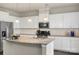 Well-equipped kitchen boasts white cabinets, granite counters, stainless appliances and a stylish backsplash at 16134 Kelby Cv, Charlotte, NC 28278