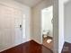 Inviting entryway featuring hardwood floors, front door with glass accents, and access to the powder room at 2713 Reid Meadows Dr, Charlotte, NC 28208