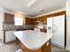 A full kitchen featuring an island, matching cabinetry, white appliances and decorative backsplash at 2713 Reid Meadows Dr, Charlotte, NC 28208