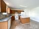 A full kitchen featuring an island, matching cabinetry, white appliances and decorative backsplash at 2713 Reid Meadows Dr, Charlotte, NC 28208