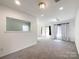 A spacious living room area with a small passthrough window into an adjacent room at 2713 Reid Meadows Dr, Charlotte, NC 28208