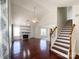 Open-concept living room with hardwood floors, vaulted ceilings, a fireplace, and staircase at 2713 Reid Meadows Dr, Charlotte, NC 28208