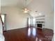 Bright living room with vaulted ceilings, hardwood floors, large windows, and a cozy fireplace at 2713 Reid Meadows Dr, Charlotte, NC 28208