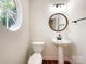 Charming powder room with pedestal sink, round mirror, and unique round window at 2713 Reid Meadows Dr, Charlotte, NC 28208