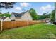 A partially fenced yard with a healthy lawn and stepped concrete patio at 305 Phillip Dr, Salisbury, NC 28146