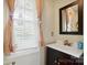 Bathroom featuring a white vanity, bronze faucet, and window with curtains at 305 Phillip Dr, Salisbury, NC 28146