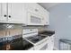 Galley style kitchen with black granite countertops and white cabinets at 305 Phillip Dr, Salisbury, NC 28146