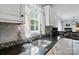 Granite countertops and decorative tile backsplash accent the stainless sink at 305 Phillip Dr, Salisbury, NC 28146