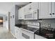 A view of the white range oven, countertop, and backsplash at 305 Phillip Dr, Salisbury, NC 28146