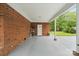 Inviting covered back porch with brick accents, providing a cool and comfortable outdoor space at 324 Autumn Dr, Harrisburg, NC 28075