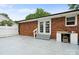 Brick house exterior view features a backyard patio with double glass doors, sink, and white fence at 324 Autumn Dr, Harrisburg, NC 28075