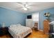 Bedroom featuring blue textured walls, wood floors, ceiling fan, and bright natural lighting at 324 Autumn Dr, Harrisburg, NC 28075