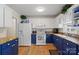 Well-lit kitchen features white appliances, blue cabinets, and granite countertops at 324 Autumn Dr, Harrisburg, NC 28075