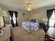 Cozy bedroom with blue patterned bedding, wood desk, and natural light from windows at 3300 Luke Ct, Monroe, NC 28112