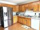 Well-lit kitchen with stainless steel refrigerator, wood cabinets, and white countertops at 3300 Luke Ct, Monroe, NC 28112