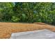 Cleared backyard space with shade trees and natural beauty, perfect for landscaping and outdoor activities at 3300 Travis Nw Ln, Concord, NC 28027