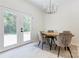 Bright dining area featuring modern lighting, wood table, and access to the backyard via double doors at 3300 Travis Nw Ln, Concord, NC 28027