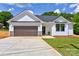 Beautiful one-story home showcasing white siding, a brown garage door, and a concrete driveway at 3300 Travis Nw Ln, Concord, NC 28027